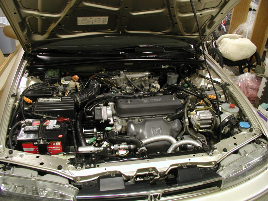 Car engine bay with open hood, showing components while explaining which gear should you use in extreme conditions for safe driving.