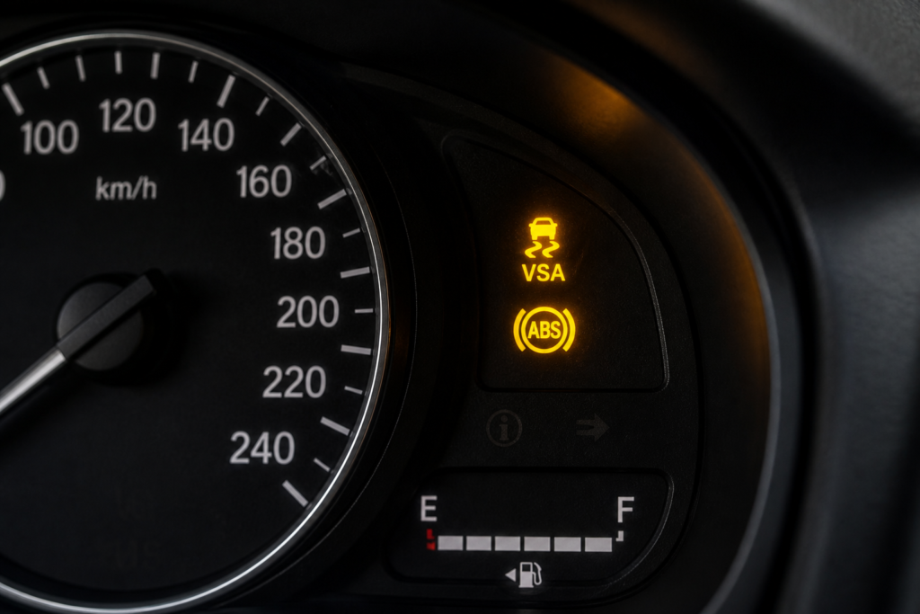 Honda Civic dashboard showing solid VSA light and ABS warning light together, highlighted clearly on the instrument cluster.
